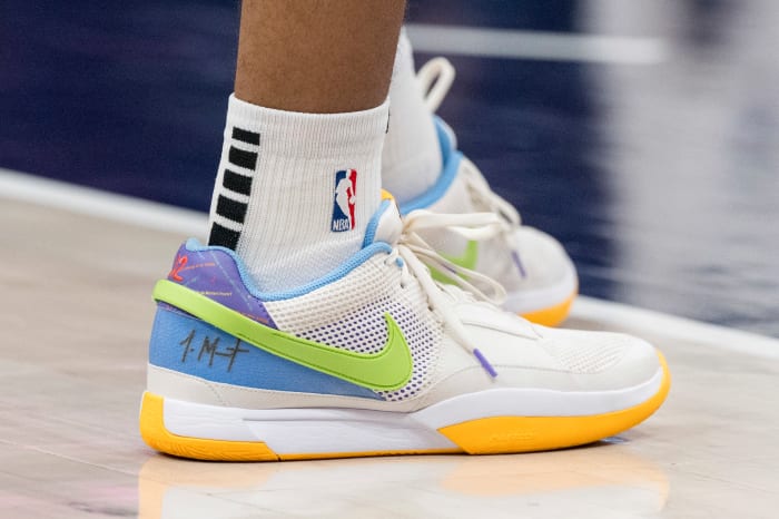 Detroit Pistons forward Tosan Evbuomwan's white and green Nike shoes.